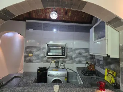 a kitchen with a stove and a microwave at Rammy Guest House in Aswan