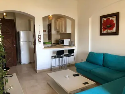 a living room with a couch and a kitchen at one bedroom ground floor sabina elgouna in Hurghada