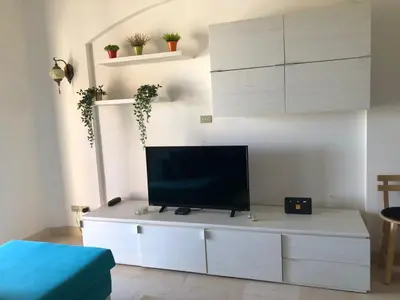 a living room with a tv on a white cabinet at one bedroom ground floor sabina elgouna in Hurghada