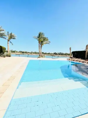 a swimming pool with palm trees in the background at 5 bedroom villa with private pool west golf elgouna in Hurghada
