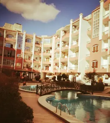a large apartment building with a bridge over a pool at Desert Bearl compound in Hurghada