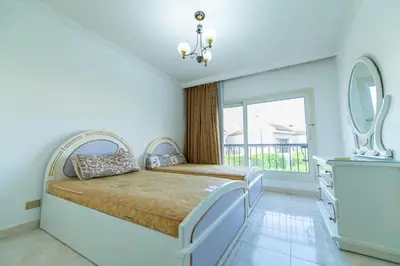 a bedroom with a bed and a large window at Hurghada Khaligeya village in Hurghada