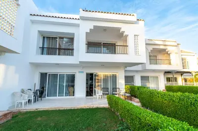 a white house with a lawn in front of it at Hurghada Khaligeya village in Hurghada