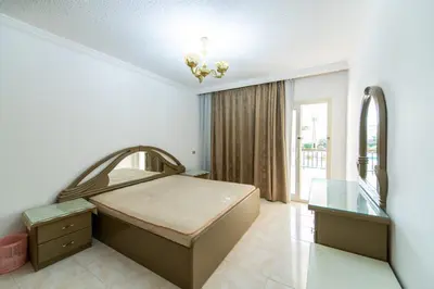 a bedroom with a bed and a desk and a mirror at Hurghada Khaligeya village in Hurghada