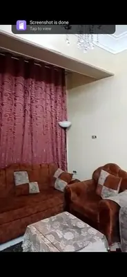 a living room with a couch and red curtains at Aswan Lovely Apartment in Aswan