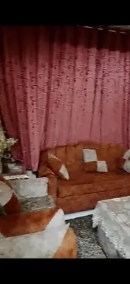 a living room with a red curtain and a couch at Aswan Lovely Apartment in Aswan