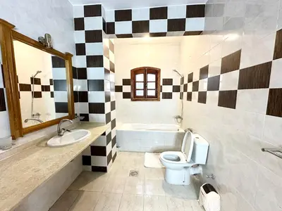 a bathroom with a toilet and a sink and a tub at Sunset Haven in Luxor