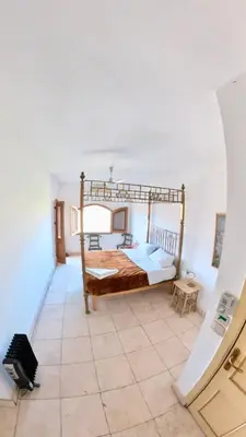 a bedroom with a bed and a tile floor at Sunset Haven in Luxor