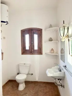 a white bathroom with a toilet and a sink at Sunset Haven in Luxor