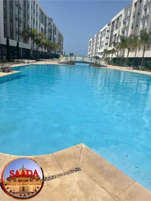 a large blue swimming pool with buildings in the background at Fanadir bay compound in Hurghada