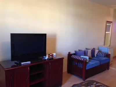a living room with a couch and a flat screen tv at Cozy studio with a view in port ghalib in Marsa Alam