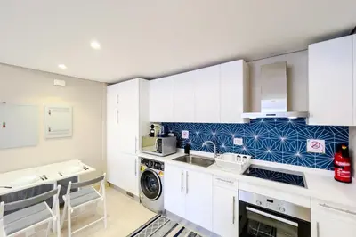 a kitchen with white cabinets and a washer and dryer at Homestyle & Summery 1BDR Mangroovy Free Beach Pool in Hurghada