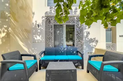 a group of blue chairs and tables on a patio at Homestyle & Summery 1BDR Mangroovy Free Beach Pool in Hurghada