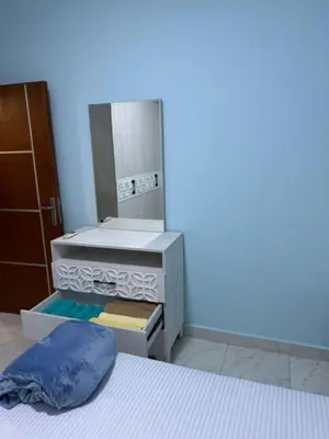 a room with a bed and a dresser with a pillow at Tiba View in Hurghada