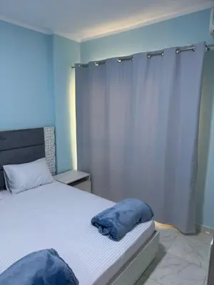 a bedroom with a bed with blue pillows on it at Tiba View in Hurghada