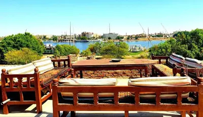 a patio with a table and chairs and a river at Blue Lotus House in Luxor
