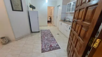 a kitchen with a refrigerator and a tile floor at Blue Lotus House in Luxor