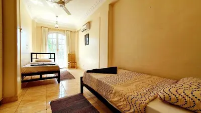 a bedroom with a bed and a room with a window at Blue Lotus House in Luxor