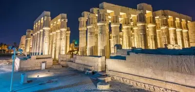 a building is lit up at night at البعيرات in Al Karnak