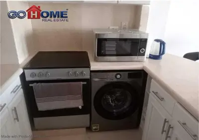 a kitchen with a microwave and a washing machine at Comfortable 1 Bedroom at Sabina El-Gouna Y160 in Hurghada