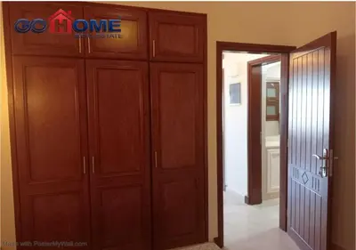 a room with wooden cabinets and a door with a sign on it at Comfortable 1 Bedroom at Sabina El-Gouna Y160 in Hurghada
