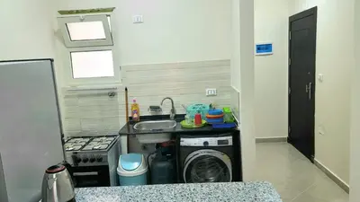 a small kitchen with a sink and a washing machine at Andalusia Palace in Hurghada