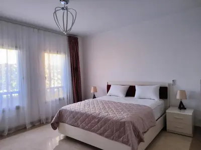 a bedroom with a bed and two windows at Elite 3bdr apartment with garden beside corral reef in Hurghada