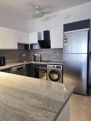 a kitchen with a stainless steel refrigerator and dishwasher at Elite 3bdr apartment with garden beside corral reef in Hurghada