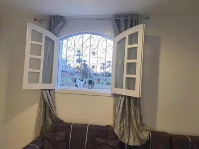 a window with curtains and a couch in front of it at Menna guest house in Luxor