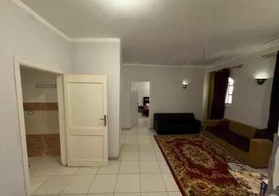 a living room with a couch and a door at The Highlander in Al Karnak