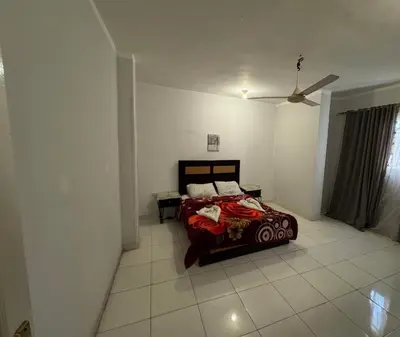 a bedroom with a bed and a ceiling fan at The Highlander in Al Karnak
