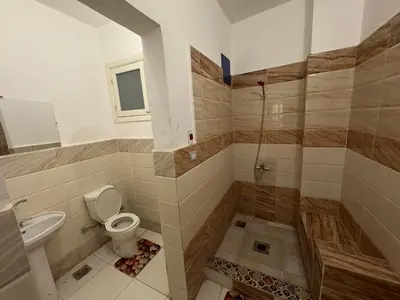 a bathroom with a toilet and a sink and a shower at The Highlander in Al Karnak