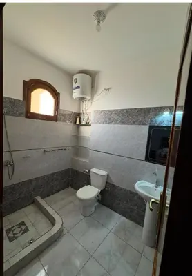 a bathroom with a toilet and a sink at The Highlander in Al Karnak