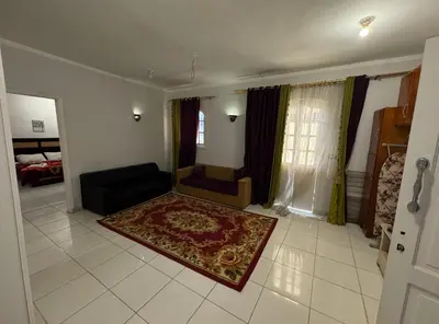 a living room with a couch and a rug at The Highlander in Al Karnak