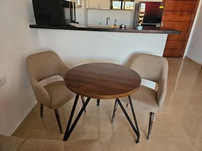 a wooden table and two chairs in a kitchen at Elhambra First Avenue in Hurghada
