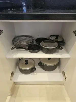 a shelf filled with pots and pans in a kitchen at Elhambra First Avenue in Hurghada