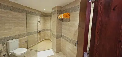 a bathroom with a toilet and a glass shower at Elhambra First Avenue in Hurghada