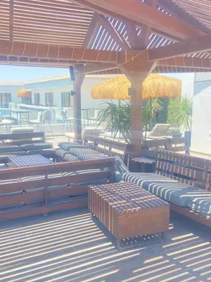 a row of benches on a deck with umbrellas at Imperial Resort Hurghada Studio pool view in Hurghada