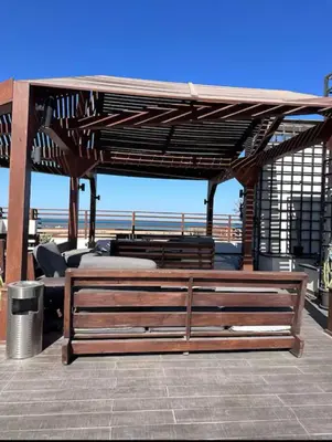 a wooden bench sitting under a pavilion on a patio at Imperial Resort Hurghada Studio pool view in Hurghada