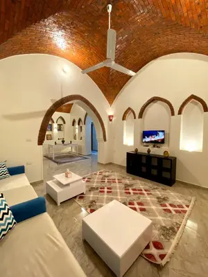 a living room with a couch and a ceiling at ELamir house in Al Aqālitah