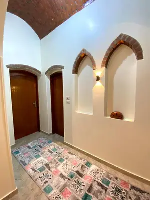 a hallway with arches and a tile floor at ELamir house in Al Aqālitah
