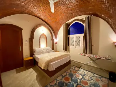 a bedroom with a bed in a brick wall at ELamir house in Al Aqālitah