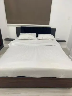 a large bed with white sheets and pillows on it at Luxurious One Bedroom Apartment in Hurghada