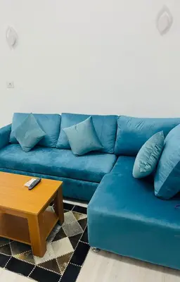 a blue couch in a living room with a coffee table at Luxurious One Bedroom Apartment in Hurghada