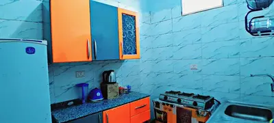a kitchen with a stove and a blue wall at Toko Sola in Jazīrat Suhayl