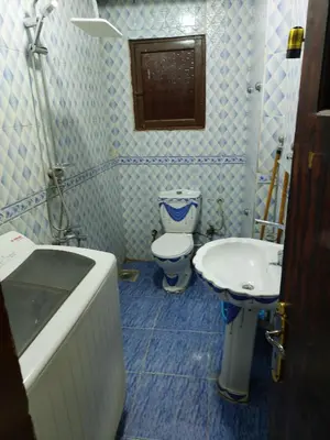 a blue and white bathroom with a toilet and a sink at Mahmoud's House in Al Manshīyah