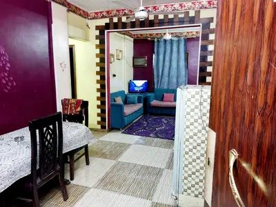 a living room with a blue couch and a chair at Mahmoud's House in Al Manshīyah
