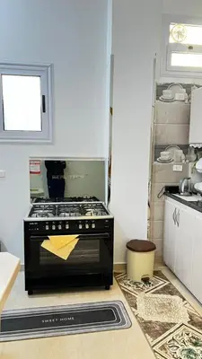 a kitchen with a black stove and a window at Seti house in Luxor