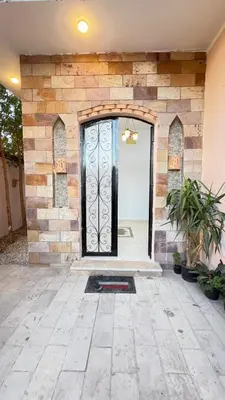 a front door of a house with a stone wall at Seti house in Luxor