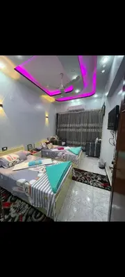 two beds in a room with purple lights on the ceiling at Hamoo guest House hotel in Aswan